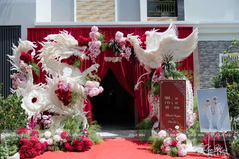 Trang Trí Gia Tiên Nha Trang: Mẫu Theo Tông Màu Ngày Cưới Cổng nhà phố phủ rèm đỏ, hai tạo hình rồng phụng trắng kết hoa đối xứng