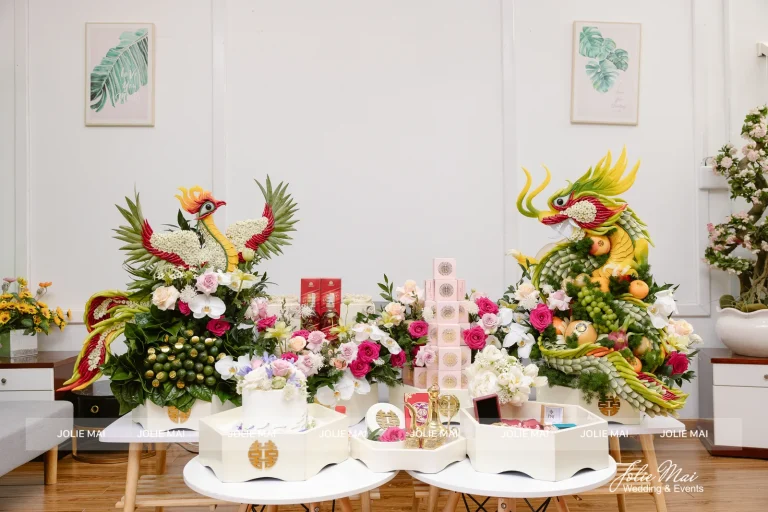 Mâm Quả Cưới Nha Trang: Bộ 5 Mâm Từ 4,7 Triệu Rồng và phụng kết từ hoa quả đứng hai đầu bộ mâm hồng trắng trong phòng sáng