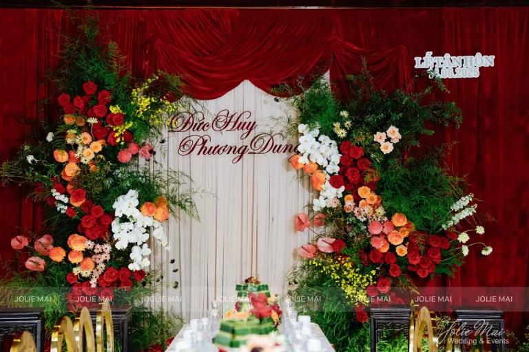 Trang Trí Gia Tiên Nha Trang: Mẫu Theo Tông Màu Ngày Cưới Phông gia tiên nhung đỏ vén cao, hoa hồng đỏ và cam ôm hai bên