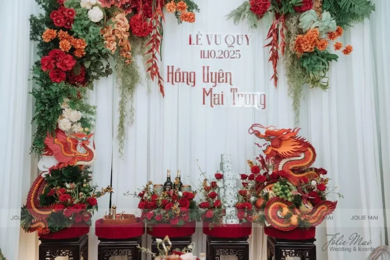 Trang Trí Gia Tiên Nha Trang: Mẫu Theo Tông Màu Ngày Cưới Bốn bục lễ nhung đỏ trước phông voan trắng, hai con rồng đỏ cam hai bên
